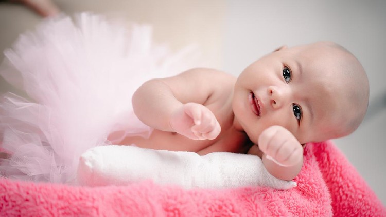 The baby was excited and delighted in the pink cloth.