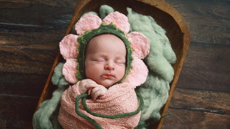 The baby was excited and delighted in the pink cloth.