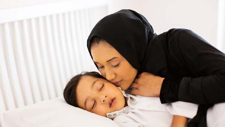 ibu dan anak caring muslim mother kissing baby boy while he is asleep