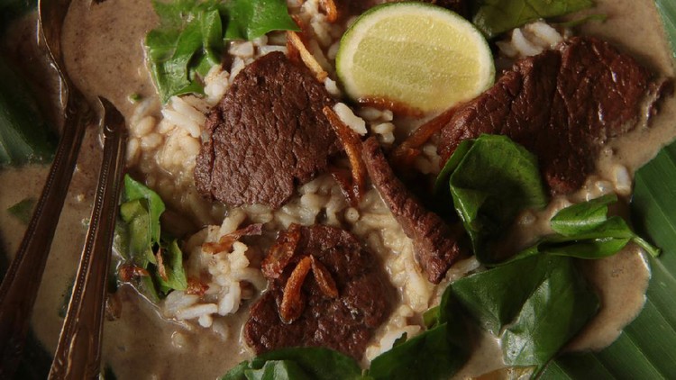 Nasi Pindang Kudus, a signature dish from Kudus city; rice served in hot soup of beef, melinjo leaves, keluak fruit, and coconut milk. The dish is served traditionally on a shallow soup plate lined with banana leaf to add more leafy fragrance to the hot dish. For a richer meal, one adds some extra side dishes served along with the rice dish.