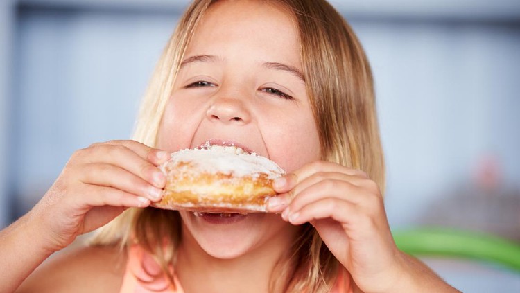 Cute asian child girl holding jelly candies in hand and sharing to other