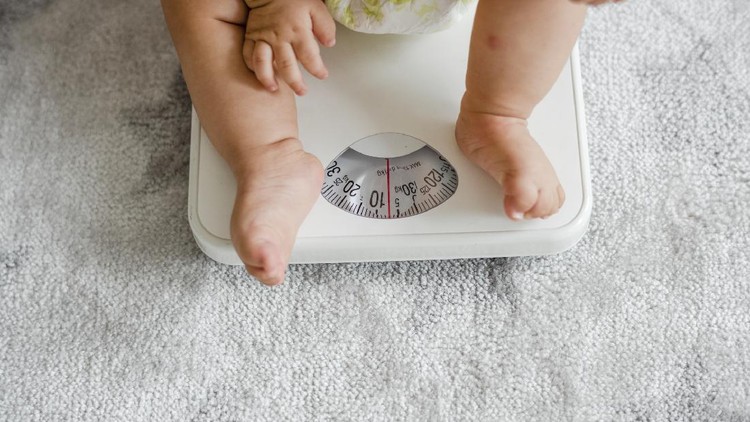 Closeup of a baby's legs on a weighing scale