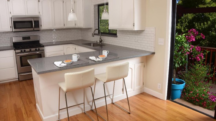 Ide Dapur Minimalis a small modern kitchen with grey cabinets and stainless steel appliances and a decorative bowl
.