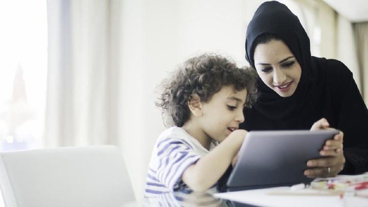 Middle eastern mother helping her child with homework.