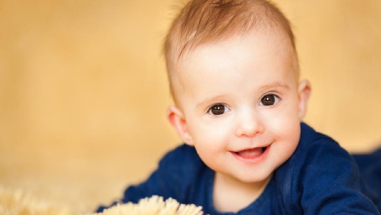 Cute baby boy with beautiful blue eyes on the white background