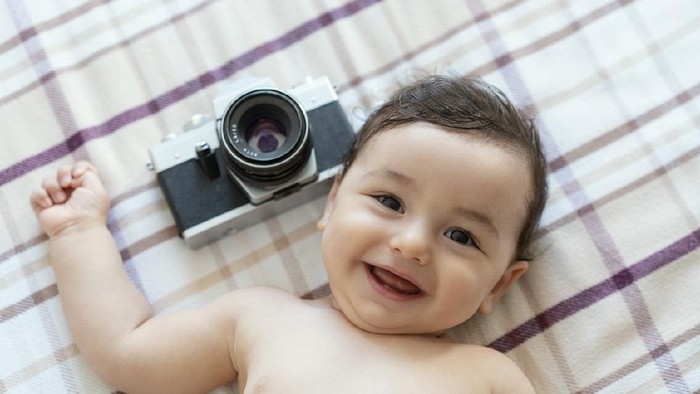 Cute baby boy with beautiful blue eyes on the white background