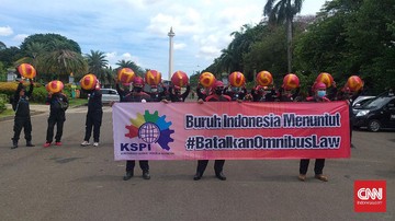 Para buruh terlihat membawa spanduk yang bertuliskan tuntutan mencabut Omnibus Law UU Cipta Kerja.