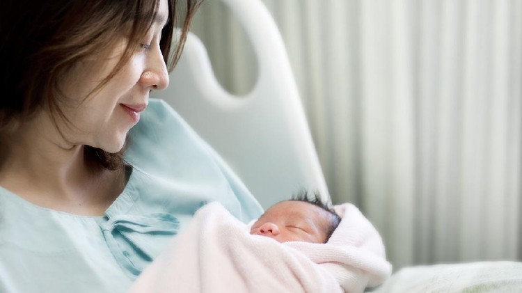 Soft focus of happy mother with newborn baby