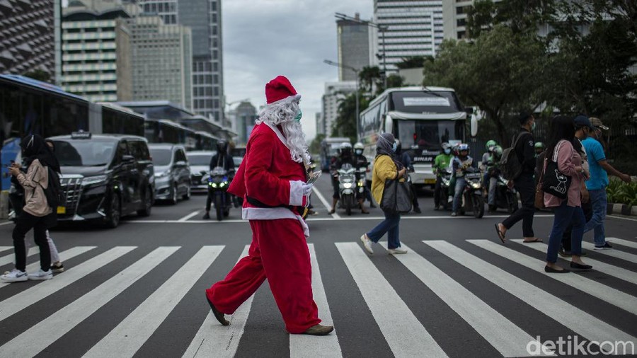 Menyambut perayaan Natal, seorang warga mengenakan baju santa membagikan kopi gratis di jalanan Ibu Kota. Ada beragam jenis kopi yang dibagikannya kepada warga.