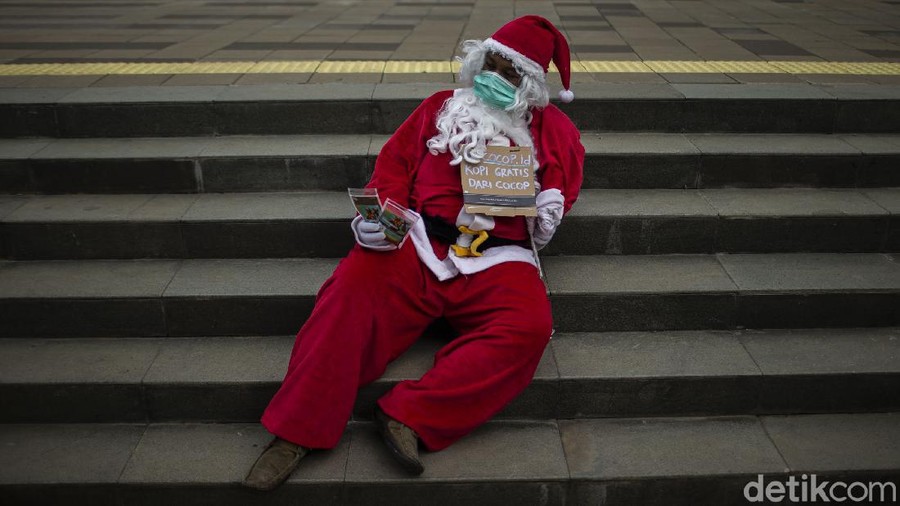 Menyambut perayaan Natal&comma; seorang warga mengenakan baju santa membagikan kopi gratis di jalanan Ibu Kota&period; Ada beragam jenis kopi yang dibagikannya kepada warga&period;