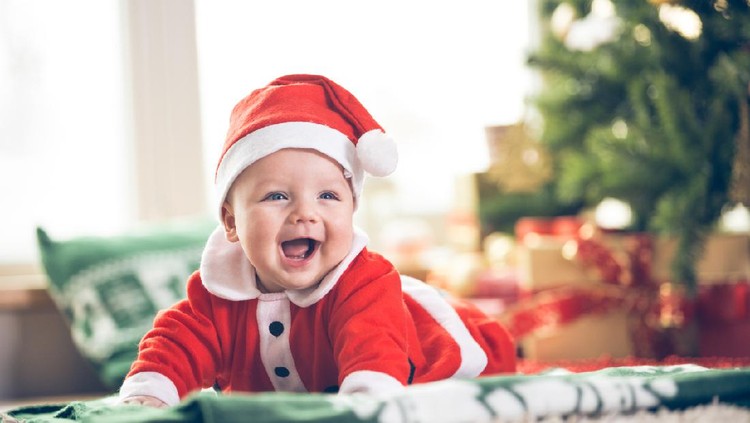 Christmas portrait of cute little newborn baby boy, wearing santa hat and  little cute snowman toy, studio shot, winter time