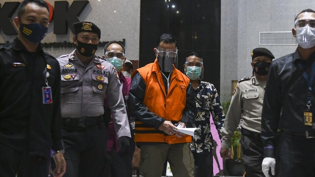 Juliari Batubara tiba di Gedung KPK dengan tangan diborgol dan membawa secarik kertas. Dia tak mau menjawab pertanyaan wartawan.