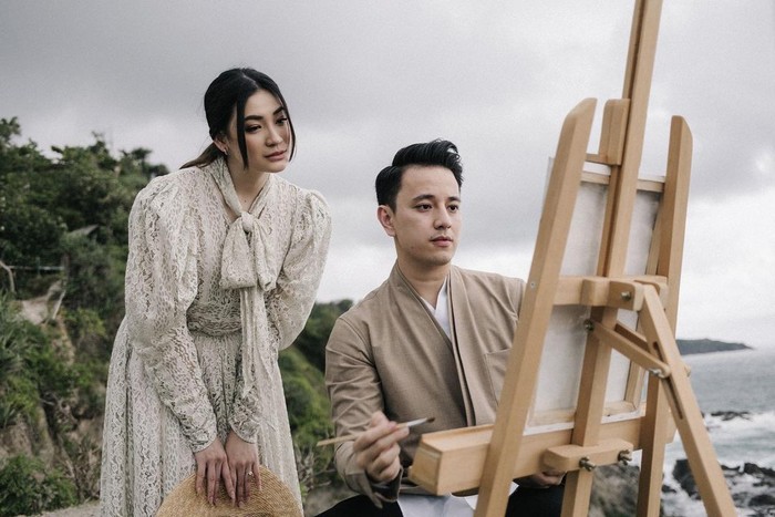 Dalam tema tersebut, Billy tampil dengan kemeja putih yang berbalut outer berwarna coklat. Sementara Patricia tampak anggun dengan mengenakan dress brukat berwarna broken white yang memiliki detail tali di bagian leher. Kompak dalam balutan busana yang senada, keduanya tampak begitu serasi berpose dengan latar belakang deburan ombak pantai. (Foto: instagram.com/caliaphoto)