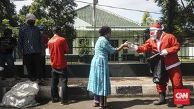 Badut Berkostum Sinterklas Berbagi Nasi Boks untuk Tuna Wisma