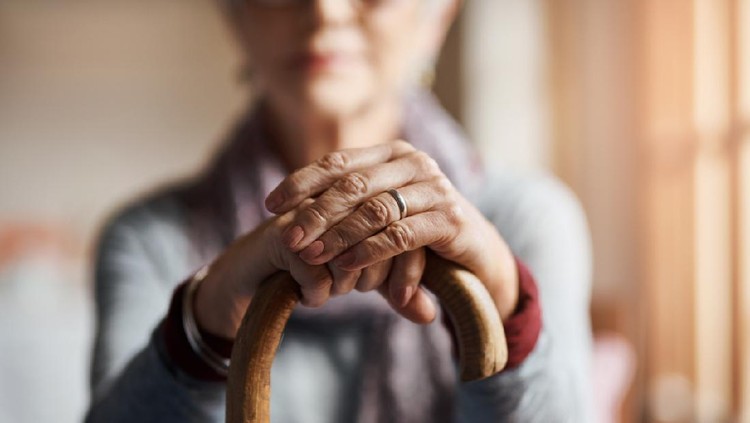 closeup senior woman hand holding walking cane to help stand at home , lifestyle of aging people concept