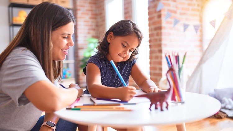 1186062153 Beautiful teacher and toddler girl drawing draw using colored pencils at kindergarten