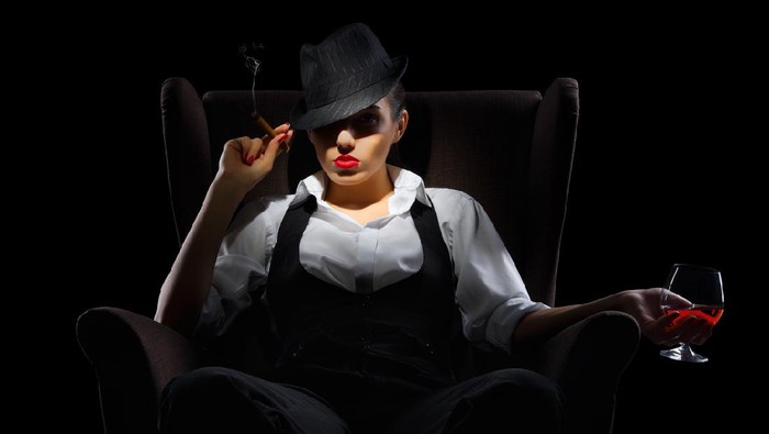 Mafiosi woman with cigar and cognac glass isolated
