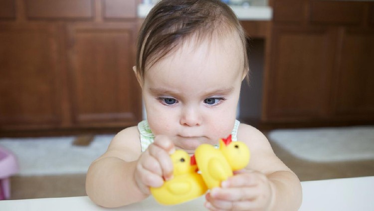 mata juling A cute Asian/Eurasian baby girl is fixated on a hanging mobile toy. Her eyes are slightly crossed as she examines it. She is just over 1 years old.