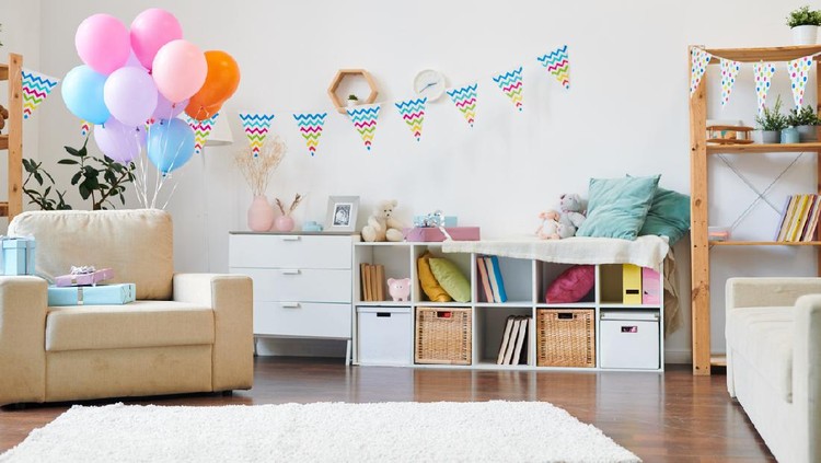 Bunch of colorful balloons and stack of giftboxes on armchair in the living-room decorated with flags for home birthday party