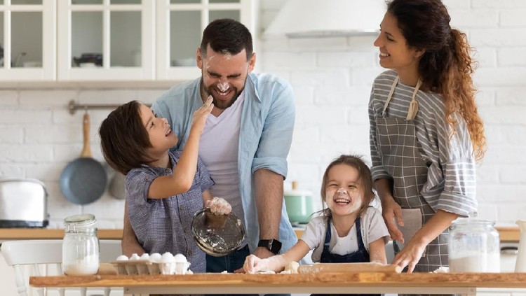 Overjoyed young family with little preschooler kids have fun cooking baking pastry or pie at home together, happy smiling parents enjoy weekend play with small children doing bakery cooking in kitchen