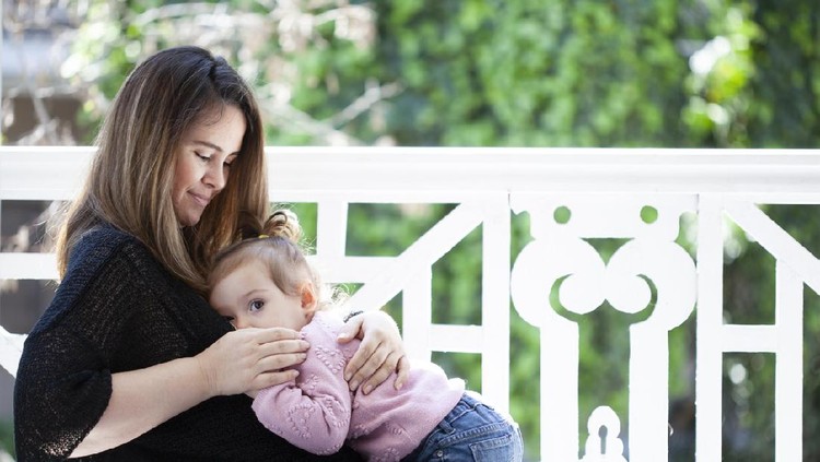 menyusui happy family photo of mother and daughter breastfeeding her baby