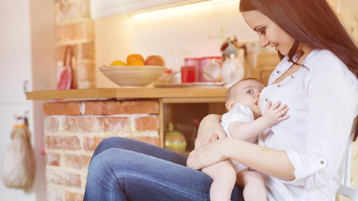 happy family photo of mother and daughter breastfeeding her baby