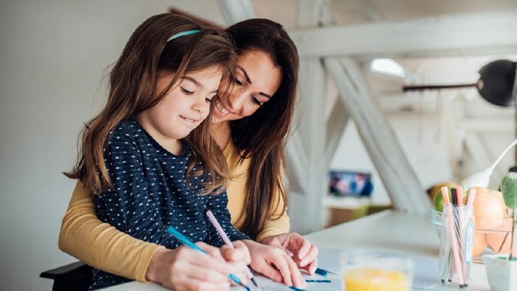Smiling woman painting along with her daughter