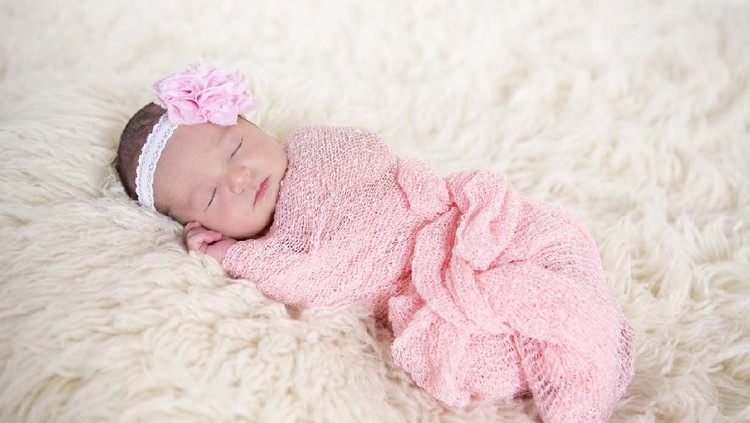 bayi perempuan Adorable two months baby girl relaxing in bedroom on knitted blanket on a sunny morning