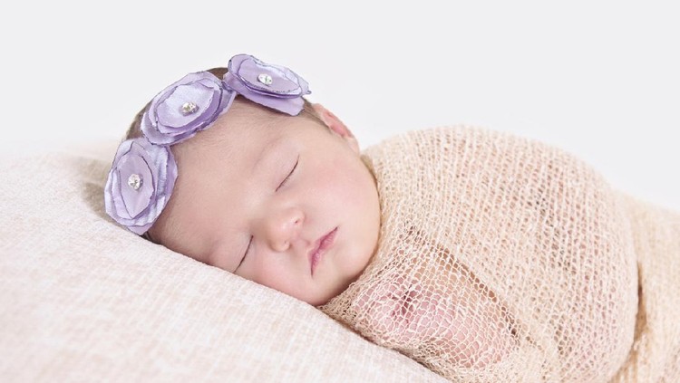bayi perempuan Adorable two months baby girl relaxing in bedroom on knitted blanket on a sunny morning