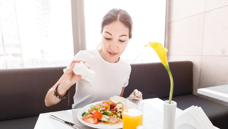 makan Asian woman in casual clothes having continental breakfast in hotel restaurant