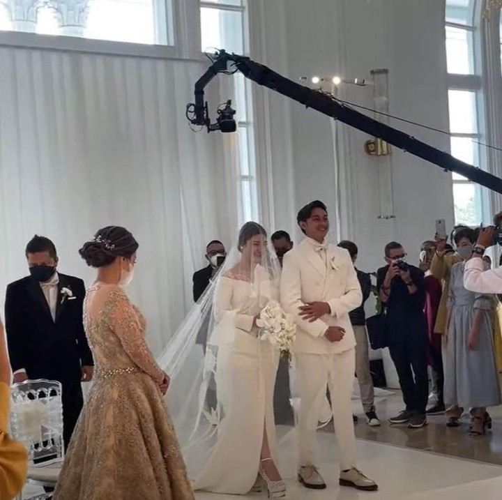 <p>Dalam acara tersebut, Caesar nampak gagah dengan setelan jas dan kemeja serba putih. Sementara Felicya nampak cantik dan anggun dalam balutan gaun putih dan veil panjang. (Foto: YouTube Felicya Angellista)</p>
