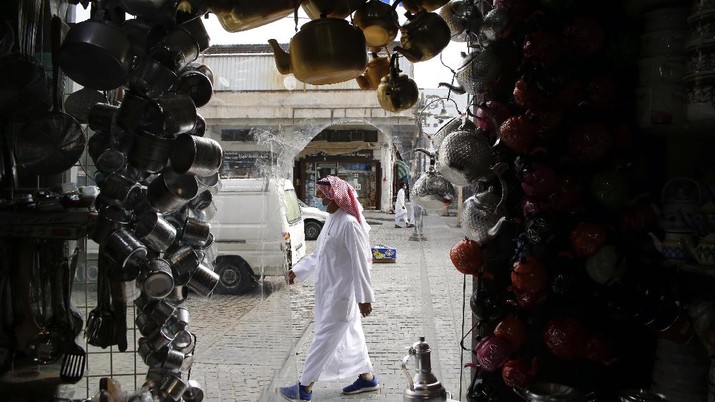 A man wearing a face mask to help curb the spread of the coronavirus, walks in front of a shop displaying teapots, at Jiddah old city, Saudi Arabia, Thursday, Dec. 17, 2020. (AP Photo/Amr Nabil)