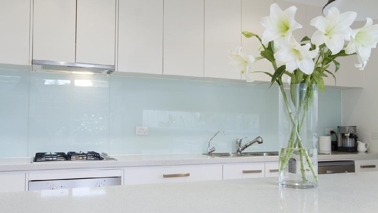 Ilustrasi dapur Flowers on white kitchen bench with splashback