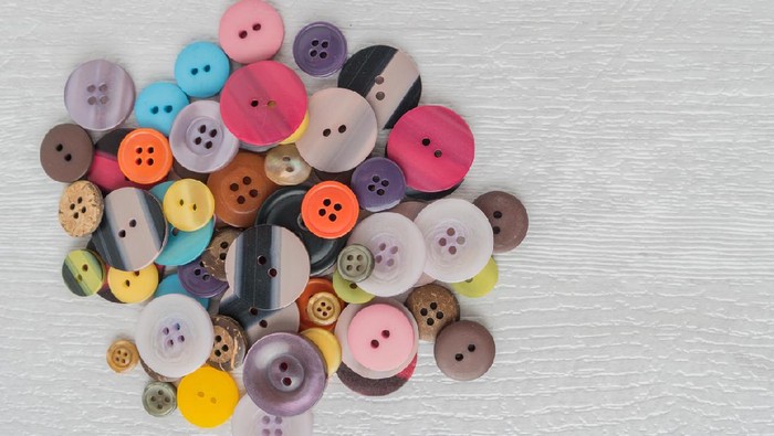 Set of different colored buttons on white background. Top of view