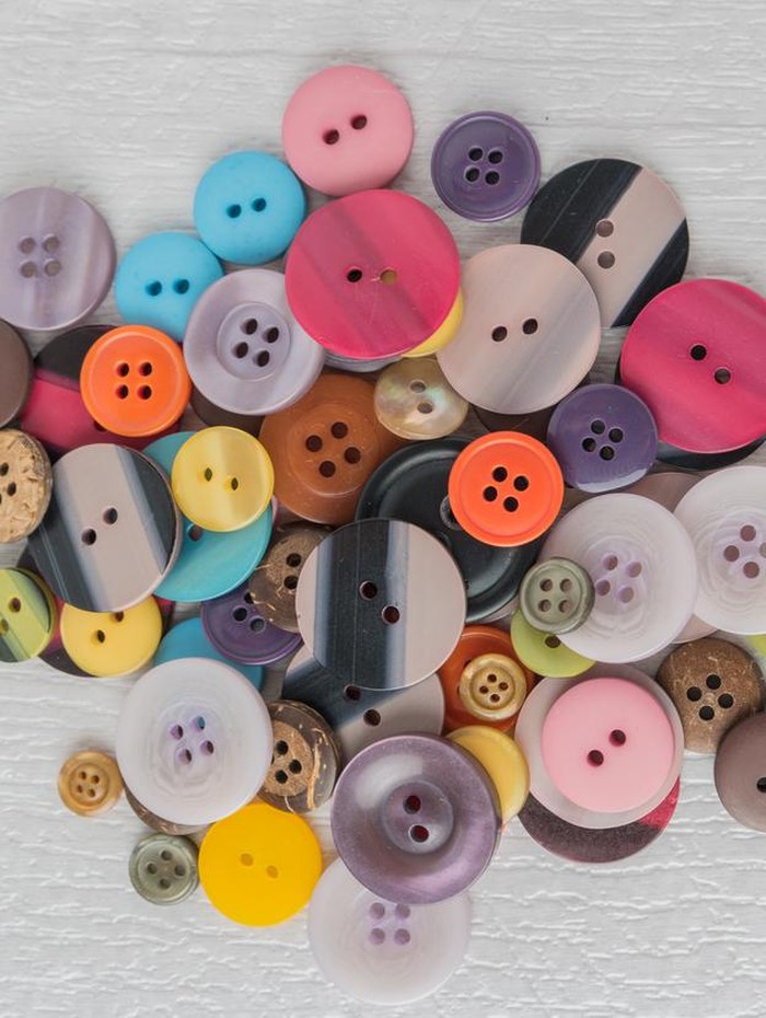 Set of different colored buttons on white background. Top of view