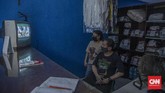 FOTO: Antusias Warga Menonton Siaran Vaksinasi Perdana Presiden Joko Widodo menerima suntikan dosis pertama vaksin corona buatan Sinovac, Rabu (13/1) pagi. Melalui televisi, warga ikut menyaksikan prosesi tersebut.