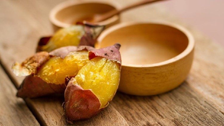 Delicious baked sweet potato with wooden spoon and cup on desk, Diet food, Low crab of vegetable concept.