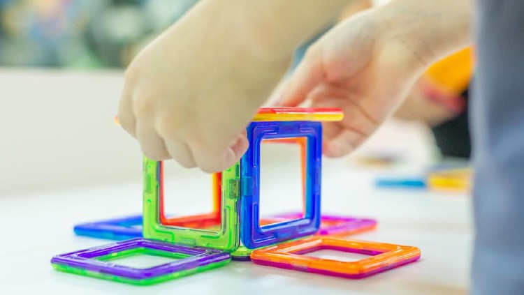 Mainan anak Magnetic block Hands of a boy assemble a magnetic constructor. in Cheboksary, Chuvashia Republic, Russia