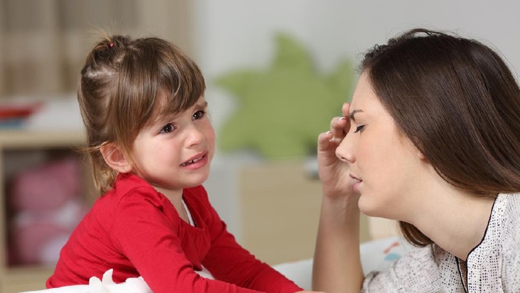 Ilustrasi anak nangis atau moody Fed up woman listening to her two years old daughter crying sitting on the bed in a house interior