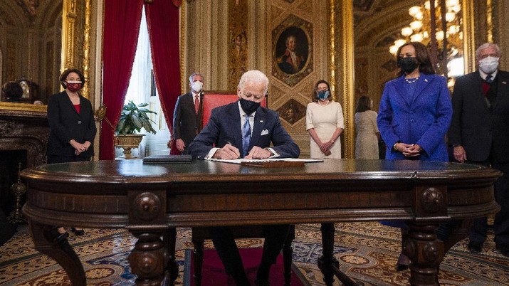 President Joe Biden signs three documents including an inauguration declaration, cabinet nominations and sub-cabinet nominations in the President's Room at the US Capitol after the inauguration ceremony, Wednesday, Jan. 20, 2021, at the U.S. Capitol in Washington. Vice President Kamala Harris watches at right. (Jim Lo Scalzo/Pool Photo via AP)