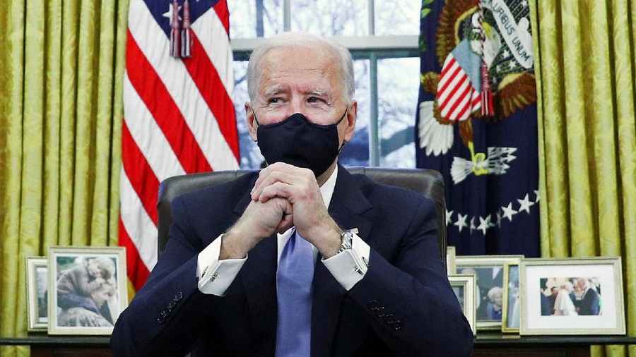FILE PHOTO: U.S. President Joe Biden signs executive orders in the Oval Office of the White House in Washington, after his inauguration as the 46th President of the United States, U.S., January 20, 2021. REUTERS/Tom Brenner/File Photo