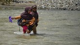 FOTO: Perjuangan Sekolah Anak Pedalaman Aceh Warga dan siswa sekolah di Desa Panca, Kecamatan Lembah Seulawah, Aceh Besar, harus berjuang menyeberangi sungai sejak jembatan gantung terputus pada 2004.