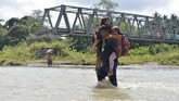 FOTO: Perjuangan Sekolah Anak Pedalaman Aceh Warga dan siswa sekolah di Desa Panca, Kecamatan Lembah Seulawah, Aceh Besar, harus berjuang menyeberangi sungai sejak jembatan gantung terputus pada 2004.