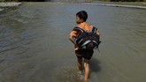 FOTO: Perjuangan Sekolah Anak Pedalaman Aceh Warga dan siswa sekolah di Desa Panca, Kecamatan Lembah Seulawah, Aceh Besar, harus berjuang menyeberangi sungai sejak jembatan gantung terputus pada 2004.