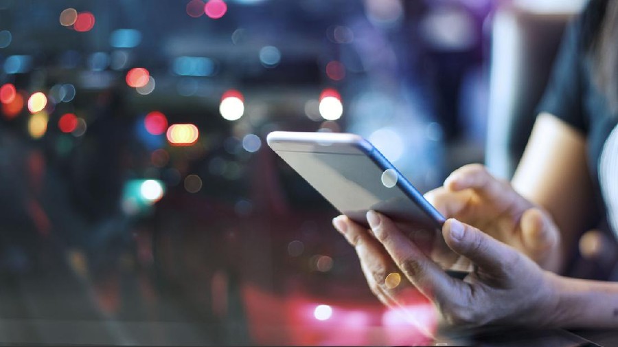 Woman using mobile smart phone in the night light colorful background