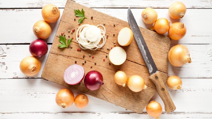 Onions with cutting board and knife on old white table. This file is cleaned and retouched.
