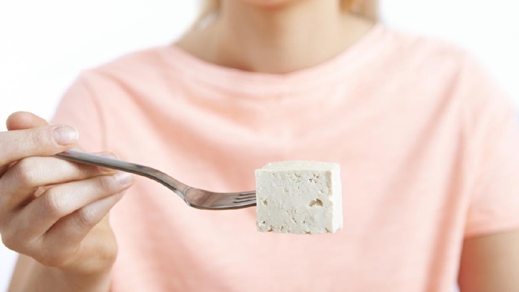 Close Up Of Woman With Tofu On Fork