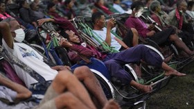 Tricycle drivers attend an outdoor movie screening held by a private organization, where cash and food donation are distributed to help them get by amid a tourism slump caused by the coronavirus disease (COVID-19) outbreak, in Phnom Penh, Cambodia Ja