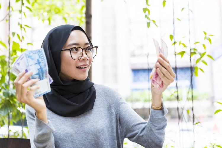 Malaysian Girl wearing hijab, rejoicing her first salary and counting cash, woman money