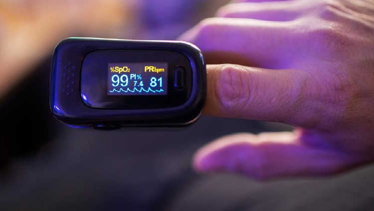 Woman hand introduced in a oximeter to check oxygen levels and pulse because Covid-19 pandemic